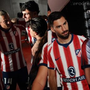 The Nike Atlético de Madrid 2026/27 Jersey home kit featuring traditional red and white stripes with a navy V-neck.