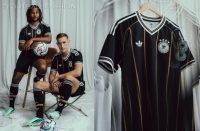 The black Germany 2026 Jersey featuring vertical gold diamond lines, white Trefoil logo, and four-star DFB badge.